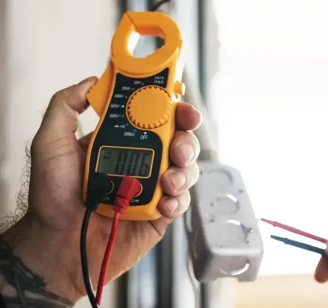 An electrician using a multimeter for electrical fault finding and voltage testing in Melbourne